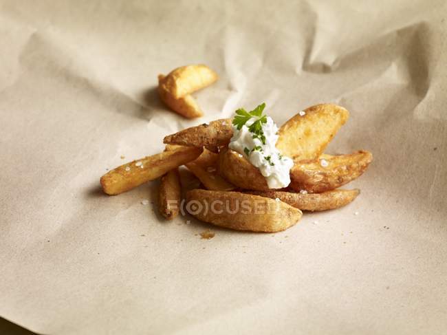 Potato wedges topped with herb dip — Stock Photo