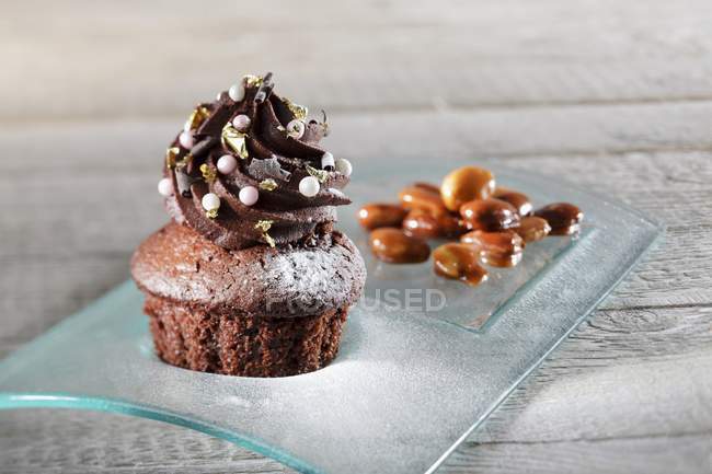 Cupcake decorated with sugar pearls and leaf — Stock Photo