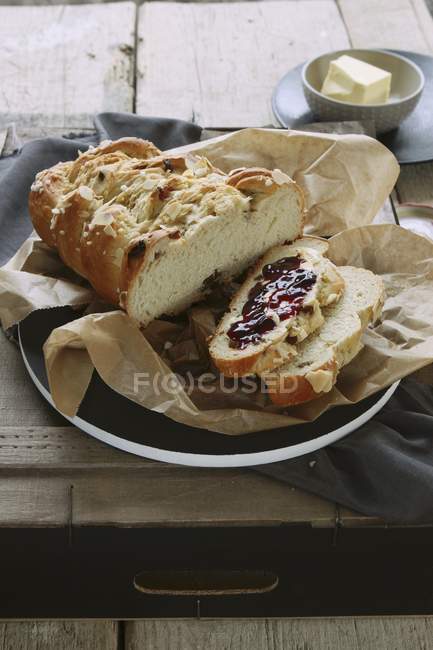 Vista elevada del pan dulce de Hefezopf con pasas y mermelada - foto de stock