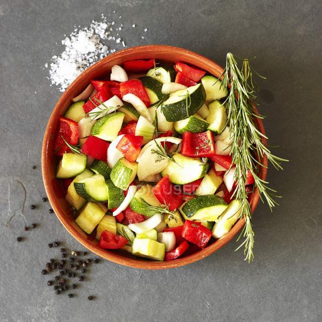 Légumes hachés au romarin dans un bol rouge — Photo de stock