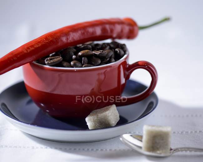 Кава в зернах в червоні чашки — стокове фото