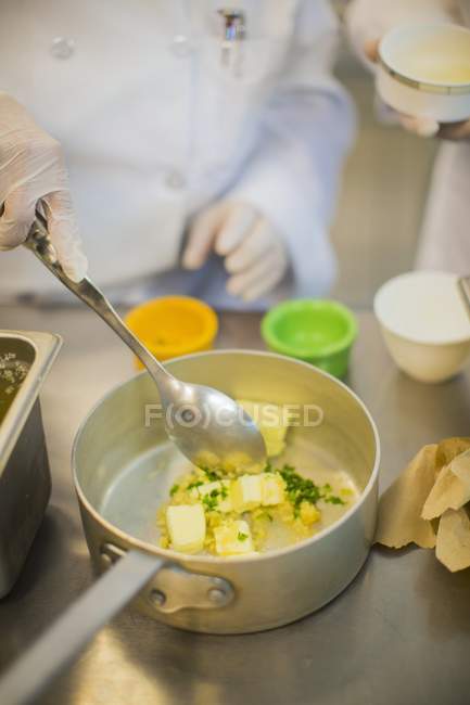 Butter, parsley and garlic in a saucepan at kitchen interior — Stock Photo