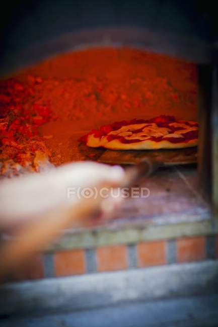 Pizza being pushed — Stock Photo