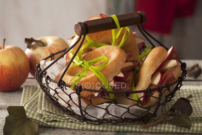 Focaccine with bacon and apple in basket over towel — Stock Photo