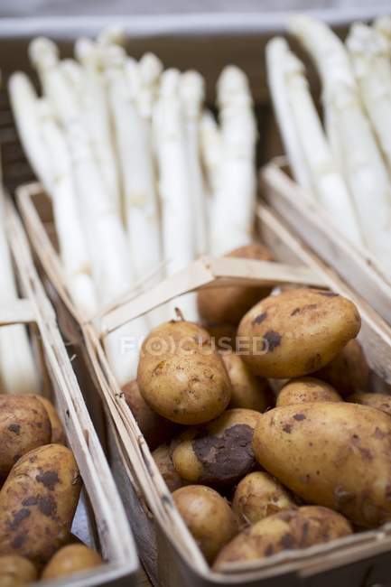Pommes de terre neuves dans un panier en bois — Photo de stock
