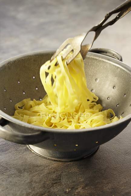 Linguine pasta in colander — Stock Photo