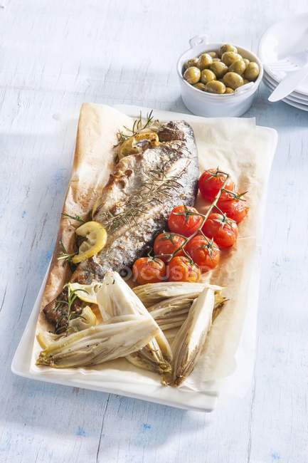 Fried fish with chicory and cherry tomatoes — Stock Photo