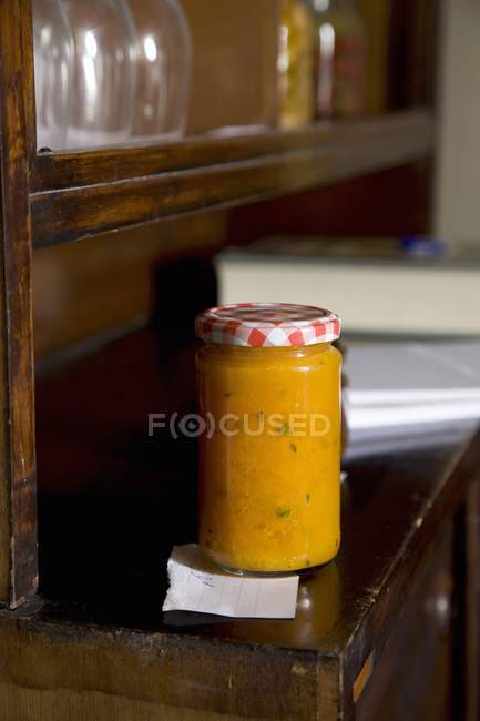 A jar of pumpkin paste on ols wooden commode — Stock Photo