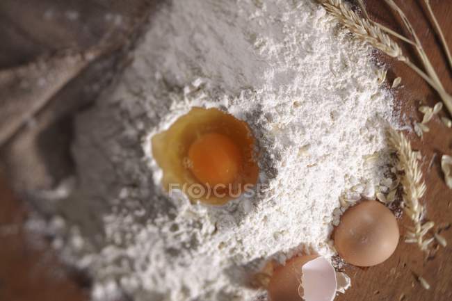 Яйцо в куче муки — стоковое фото