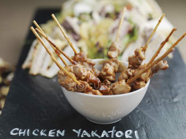 Vista de cerca de pollo Yakatori pinchos en tazón - foto de stock
