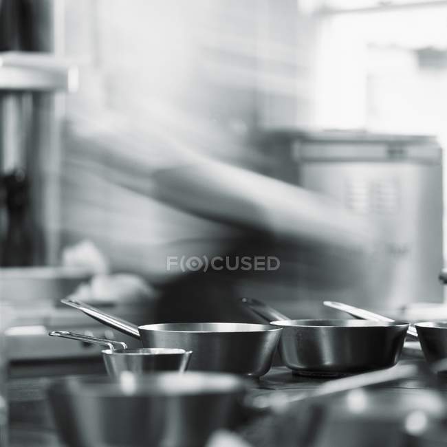 Chef desfocado e panelas de metal em uma cozinha restaurante — Fotografia de Stock