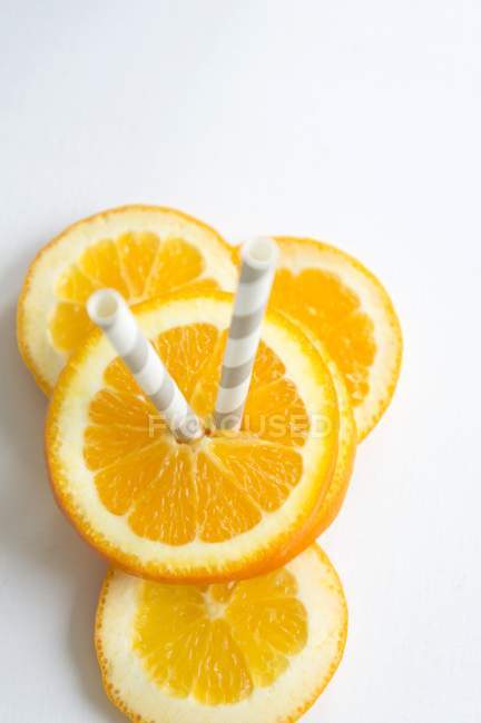 Оранжевые ломтики с соломой — стоковое фото