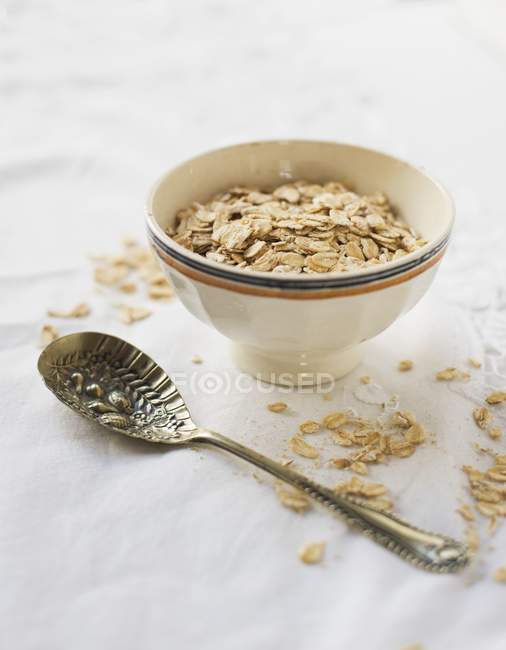 Vue surélevée d'un bol d'avoine au porridge et d'une cuillère vintage — Photo de stock