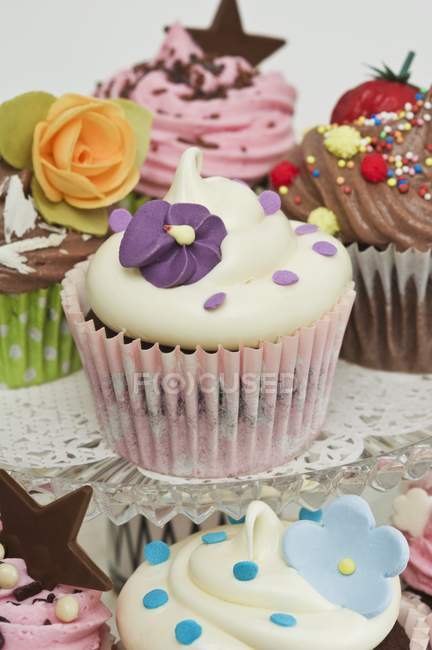 Различные кексы украшены сахарными цветами — стоковое фото