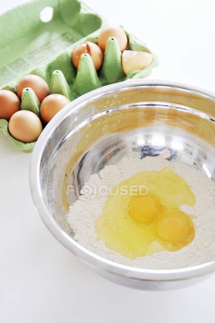 Farinha e ovos em tigela de mistura — Fotografia de Stock