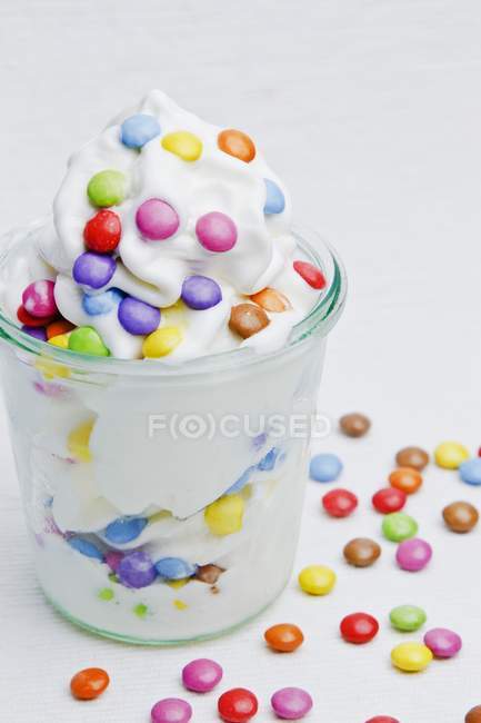 Closeup view of frozen yogurt with colorful chocolate beans — Stock Photo