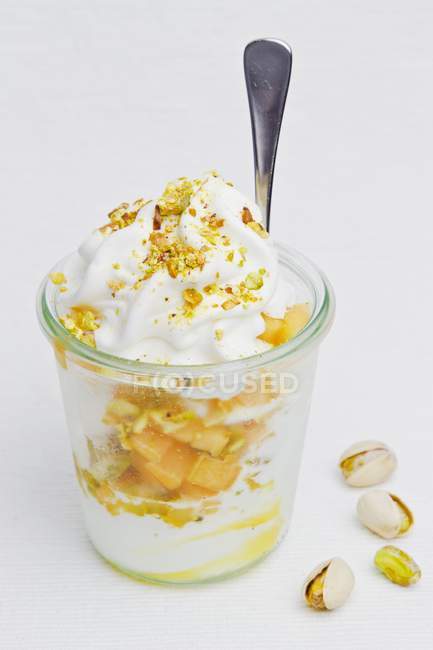 Closeup view of frozen yogurt with fruit and pistachios — Stock Photo