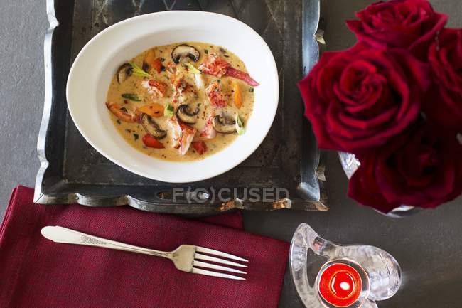 Vista dall'alto della zuppa di aragoste con funghi e bouquet di rose — Foto stock