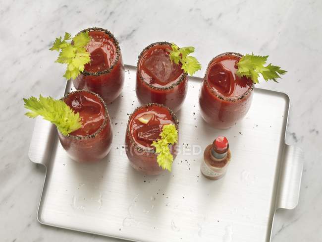 Cinco Bloody Marys decorados com aipo em uma bandeja — Fotografia de Stock