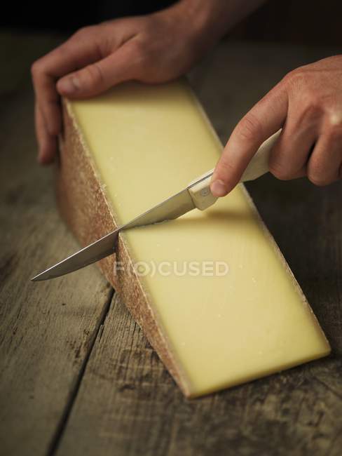 Gruyere cheese being sliced — Stock Photo