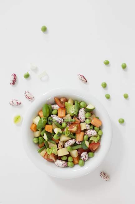 Una ciotola bianca di verdure zuppa su superficie bianca — Foto stock