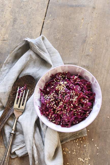 Small bowl of red cabbage salad with sesame on wooden table — Stock Photo