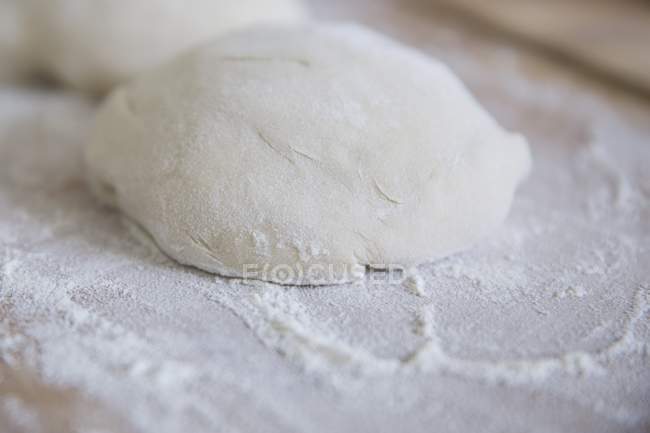 Pizza dough on board — Stock Photo