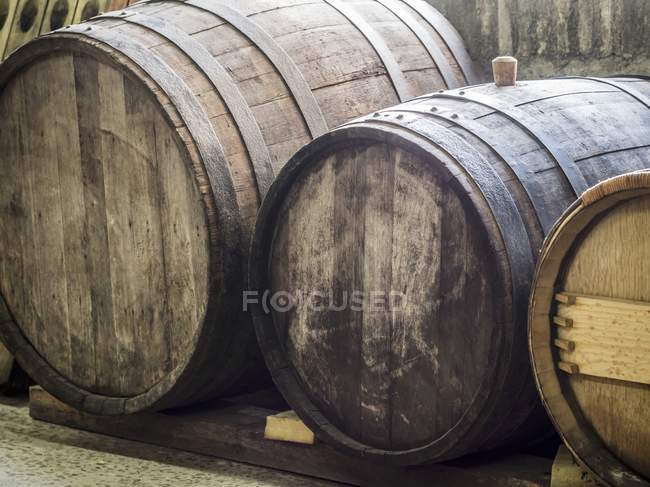 Velhos barris de vinho de madeira em uma adega — Fotografia de Stock