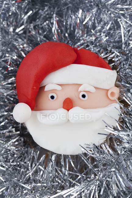 Cupcake on silver tinsel — Stock Photo