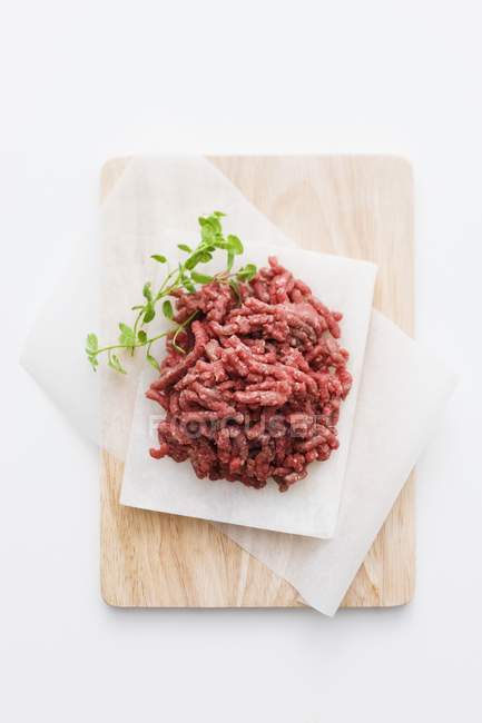 Fresh minced beef on paper — Stock Photo