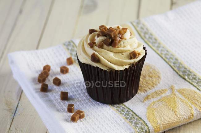 Cupcake decorated with toffee pieces — Stock Photo