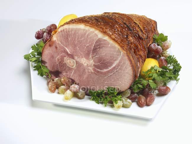 Roasted ham with sugared grapes — Stock Photo