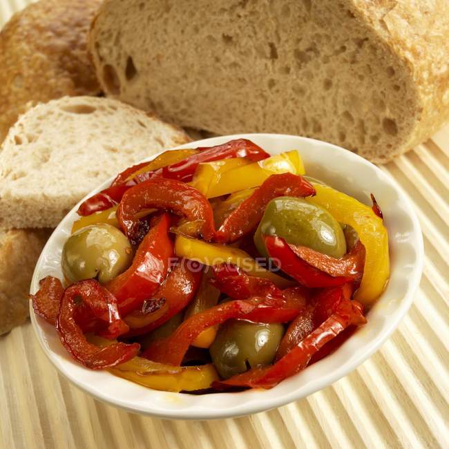 Красный и желтый перец с зелеными оливками — стоковое фото