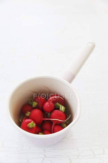 Fresh radishes in saucepan — Stock Photo