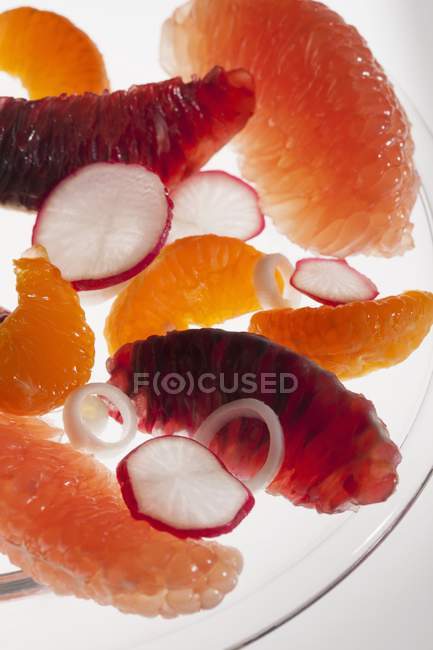 Ensalada de cítricos con naranjas peladas, pomelo, naranja sangre, rábanos y cebollas - foto de stock