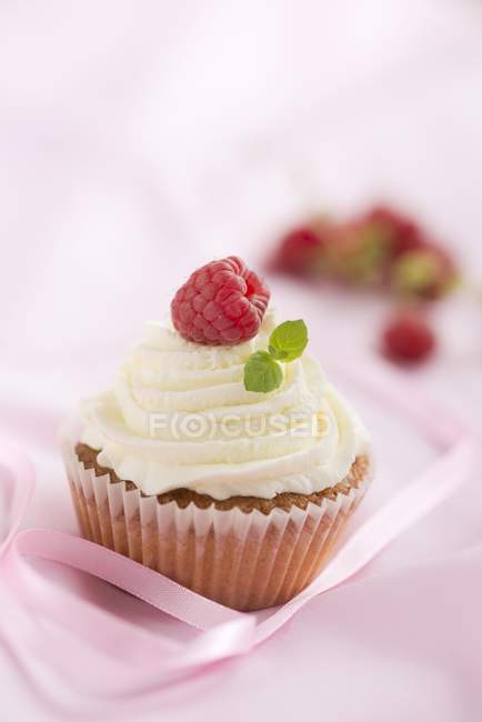 Cupcake with buttercream and raspberry — Stock Photo