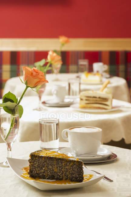 Pastel de semillas de amapola y café en la mesa - foto de stock