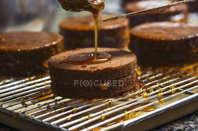 Glaze being drizzled over apricot cakes — Stock Photo