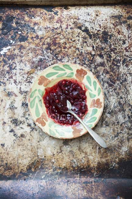 Redcurrant jam on vintage plate — Stock Photo