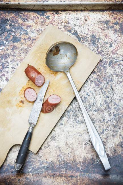 Saucisse tranchée avec couteau — Photo de stock