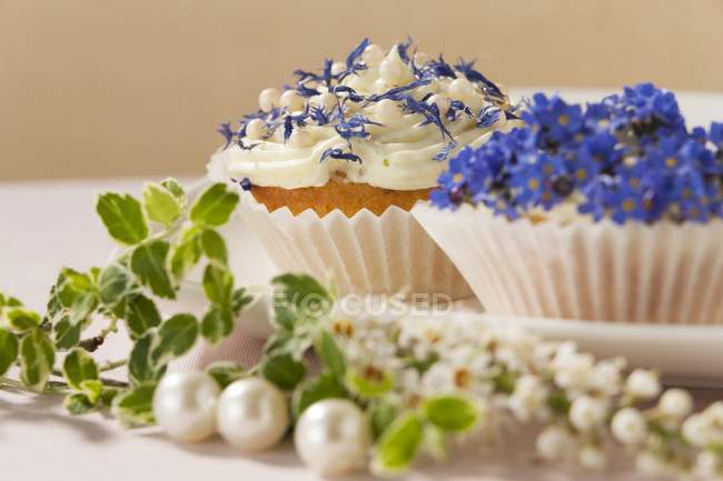 Cupcakes decorated with spring flowers — Stock Photo
