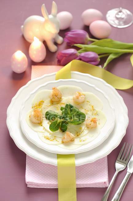 Kohlrabi-Carpaccio mit Garnelen und Feldsalat zu Ostern in weißem Teller über Handtuch — Stockfoto