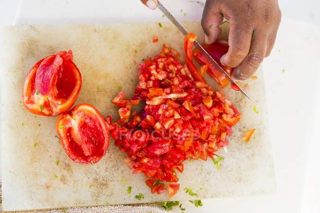 Manos humanas picando tomates - foto de stock