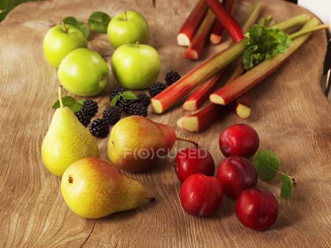 Крупный план расположения органических фруктов на деревянной поверхности — стоковое фото