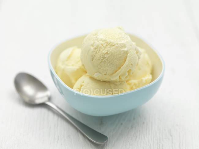 Bowl of vanilla ice cream on table — Stock Photo