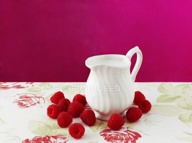 Raspberries and jug of cream — Stock Photo