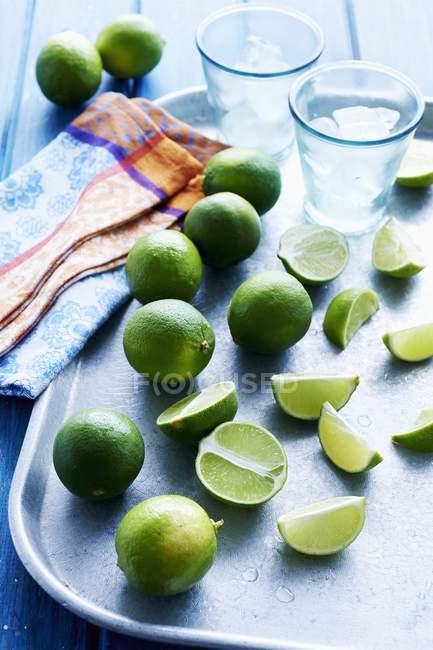 Fresh limes with wedges — Stock Photo