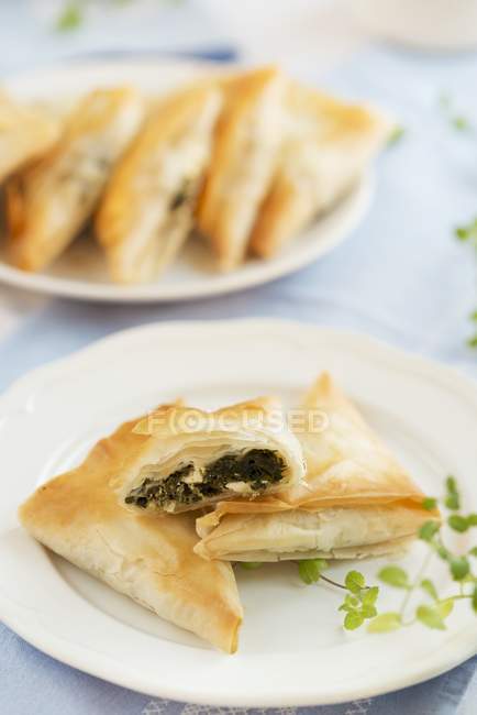 Tasche di pasta sfoglia piene di spinaci su piastra bianca — Foto stock