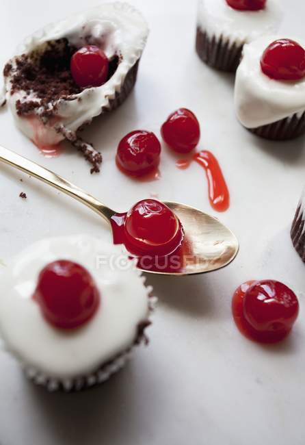 Bolos decorados com açúcar de confeiteiro e cerejas — Fotografia de Stock