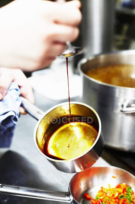 Vue recadrée de la personne caramélisant le sucre dans une casserole — Photo de stock